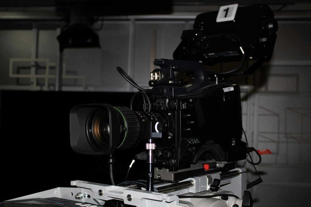 Close-up of a professional video camera rig in a studio environment, highlighting its complexity.